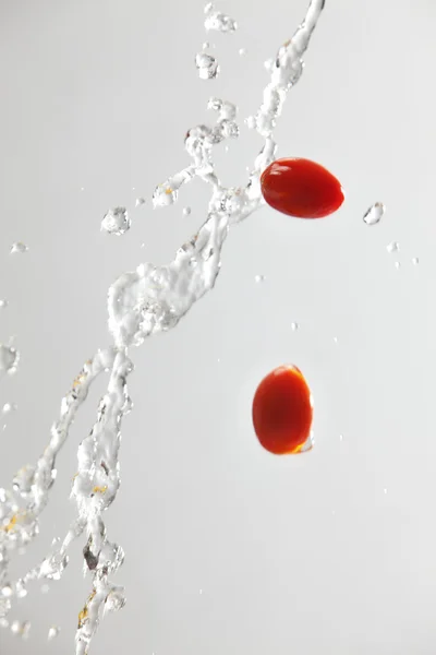 Dziecko pomidor z plusk wody — Zdjęcie stockowe