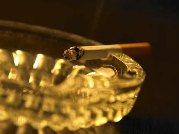Odpočinek cigaretu na popelník s kouřem — Stock fotografie