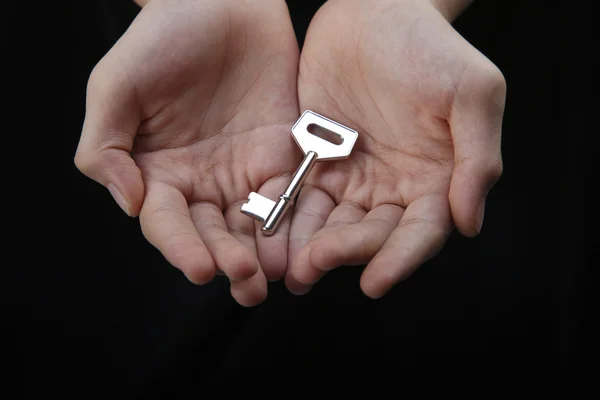Δύο χέρι Ανοίξτε δείχνει ένα κλειδί — Φωτογραφία Αρχείου