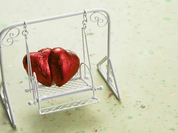 Two heart shape chocolate on the swing — Stock Photo, Image