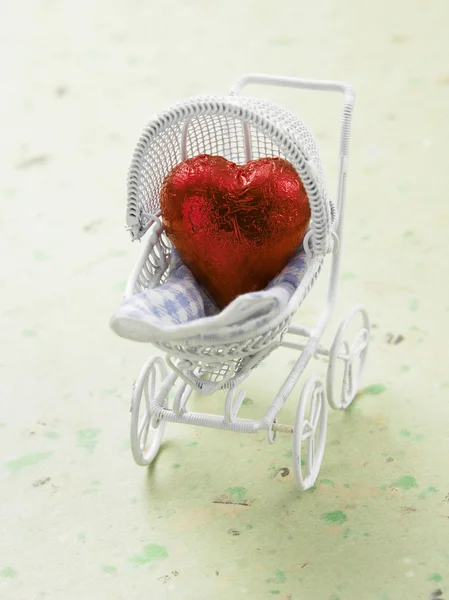 Herzförmige Schokolade wie ein Baby im Einkaufswagen — Stockfoto
