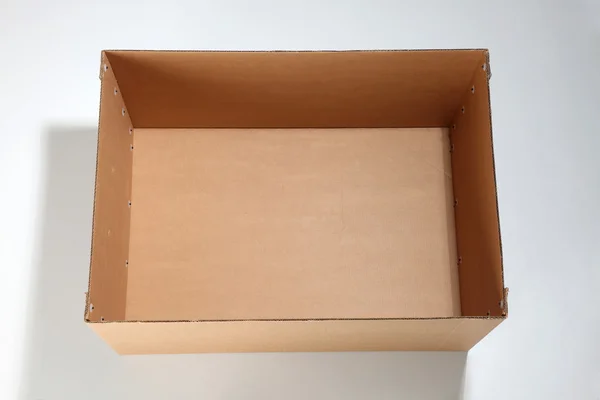 Caja de cartón marrón vacía abierta sobre el fondo liso —  Fotos de Stock