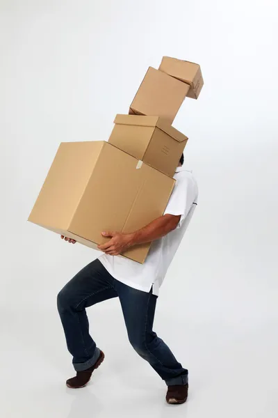 Bir adam hareketli kutularını taşımak için mücadele — Stok fotoğraf
