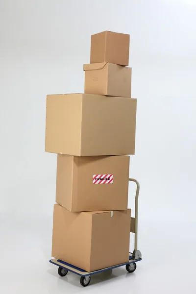 Boxes stack up on top of trolley — Stock Photo, Image