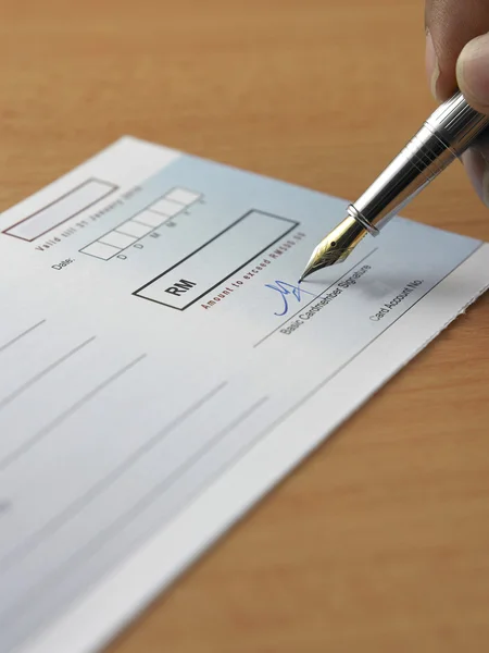 Fechar de uma caneta em um livro de cheques no fundo branco — Fotografia de Stock