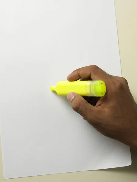 Primo piano della mano che tiene un evidenziatore giallo — Foto Stock