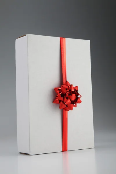 Красная лента на белой коробке — стоковое фото
