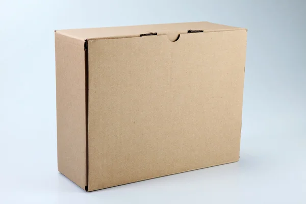 Caja de cartón de color marrón en el fondo de color liso —  Fotos de Stock