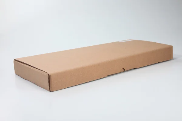 Caja de cartón de color marrón en el fondo de color liso — Foto de Stock