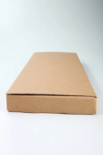 Коричневая картонная коробка на обычном фоне — стоковое фото