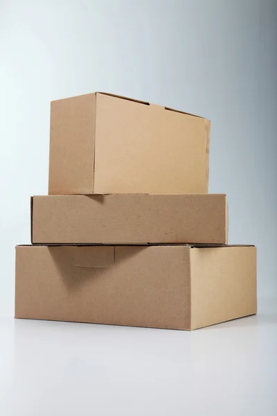 Algunas cajas apiladas en el fondo de color liso — Foto de Stock