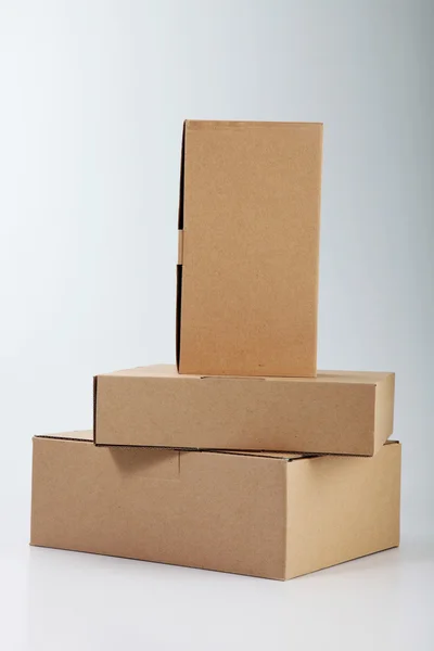 Några lådor staplas på vanlig färg bakgrunden — Stockfoto