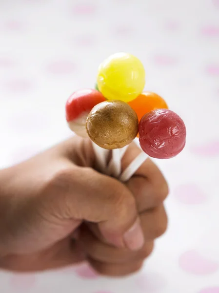 Hand som håller ett gäng lollipop — Stockfoto