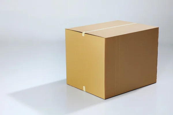 Hnědý box na obyčejné barvy pozadí — Stock fotografie
