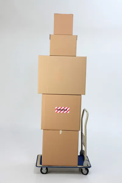 Boxes stack up on top of trolley — Stock Photo, Image