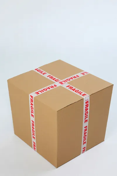 stock image Brown cardboard box sealed with fragile sign