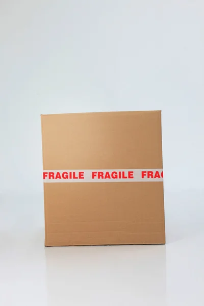 Boîte en carton marron scellée avec signe fragile — Photo