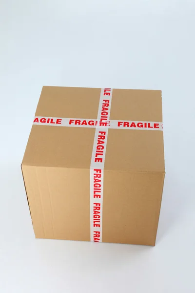Caja de cartón marrón sellada con signo frágil — Foto de Stock