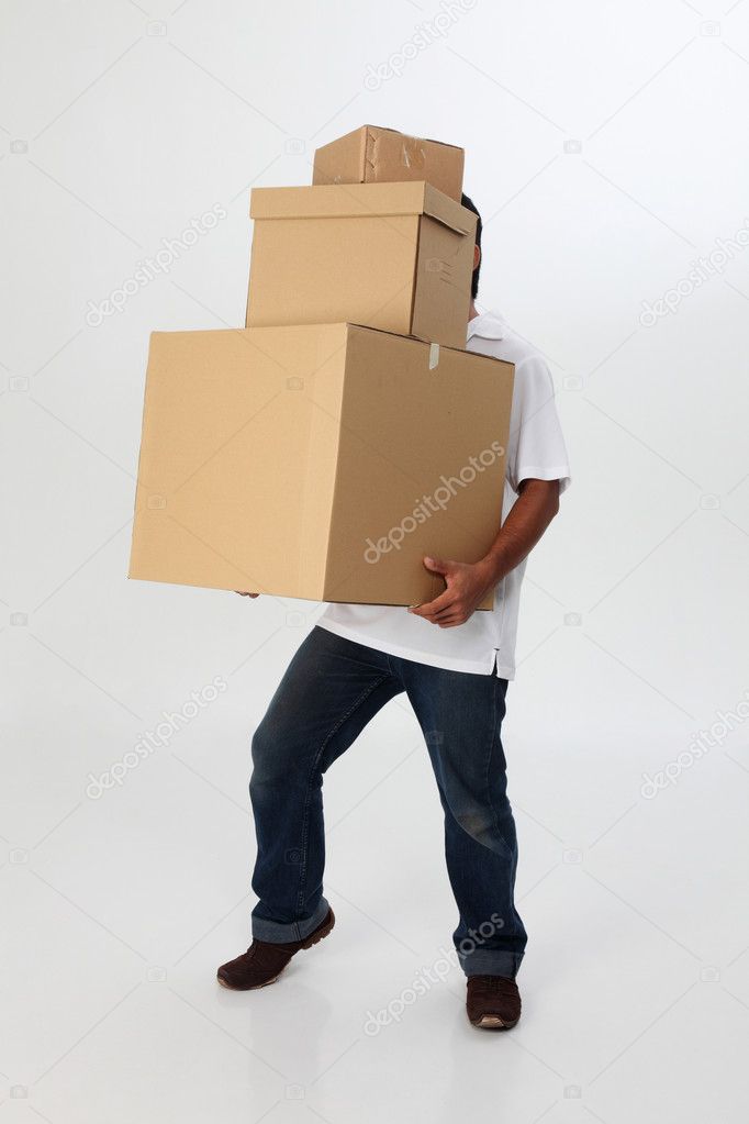 A man struggling to carry moving boxes