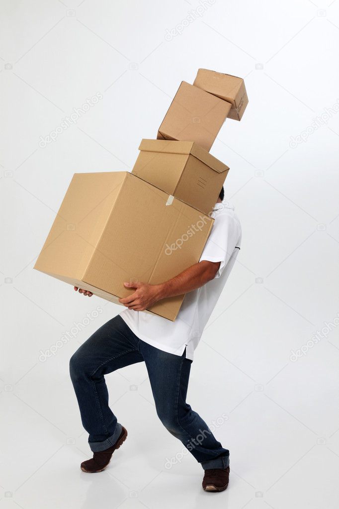 A man struggling to carry moving boxes.