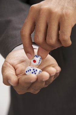 Close up of man picking up a dice clipart