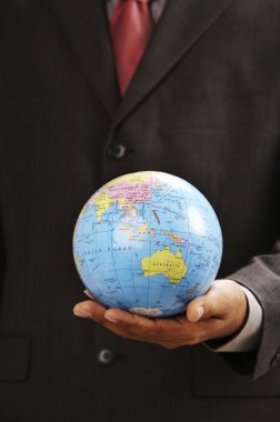 Man holding a desk globe on the palm clipart