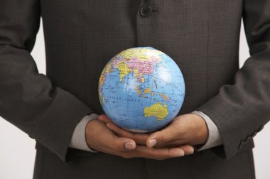 A man holding a desk globe with two hands clipart