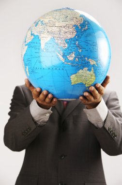 Businessman holding globe over face clipart