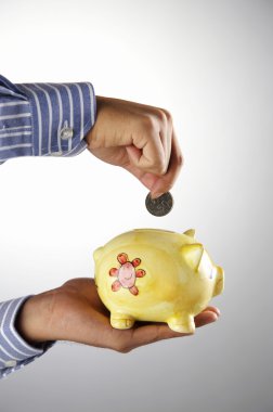 Man saving money in the piggy bank clipart