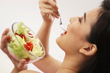 Salata yiyen genç kadın.