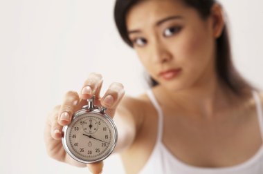 Young woman holding a stop watch clipart