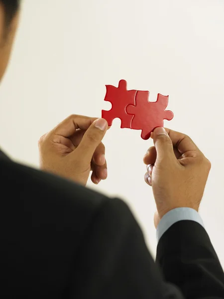 stock image Man fixing the red color puzzle