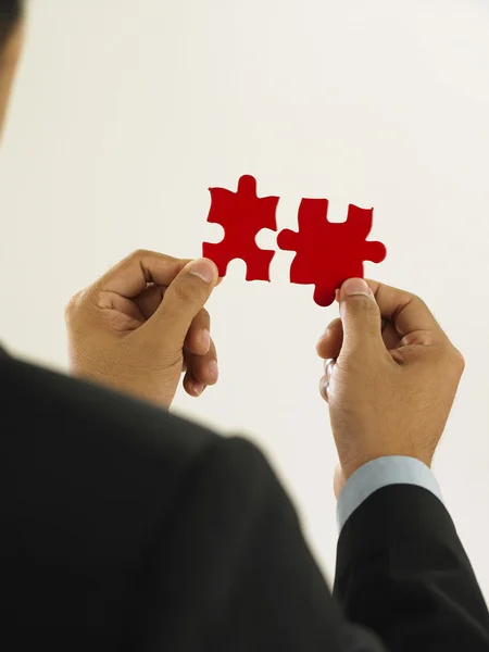 Businessman is fixing the red color puzzle — Stock Photo, Image