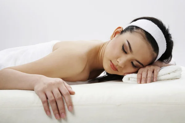 Mujer joven con banda de pelo en la cama de masaje —  Fotos de Stock