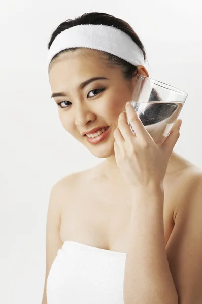 Mujer en toalla sosteniendo agua de vidrio —  Fotos de Stock