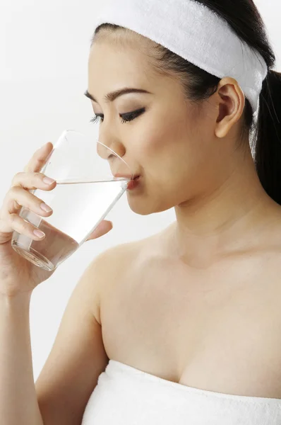 Woman in towel drinking water — Stock Photo, Image