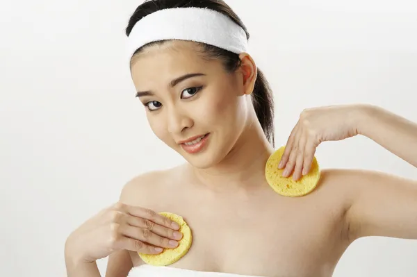 Mulher limpando seu peito com esponja — Fotografia de Stock