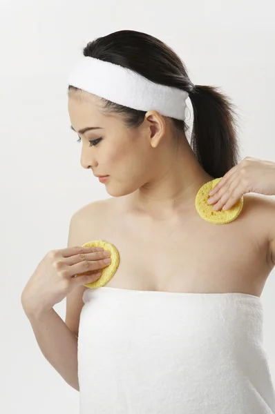 Woman cleaning her chest with sponge — Stock Photo, Image