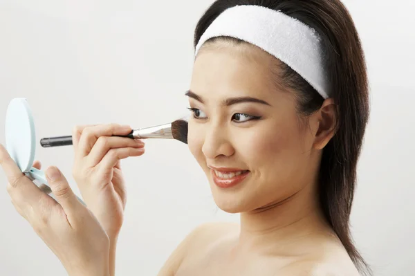 Mujer joven que aplica maquillaje después del baño —  Fotos de Stock