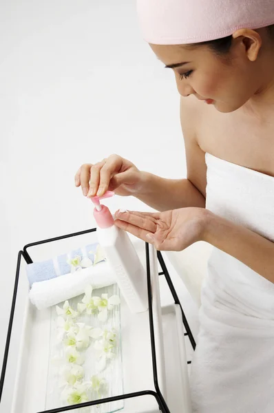 Женщина берет крем для рук из автомата — стоковое фото