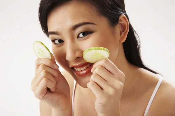 Young Woman Holding Cucumber Slice Over Eye — Stock Photo, Image