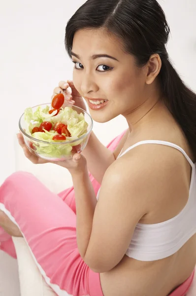 Jeune femme manger de la salade — Photo