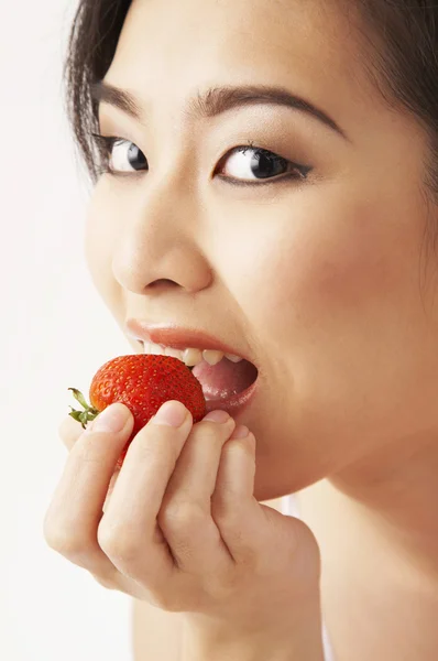 Jonge vrouw die aardbeien eet — Stockfoto