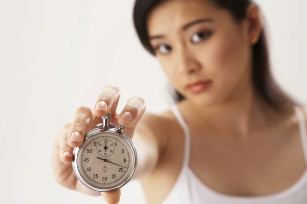 stock image Young woman holding a stop watch