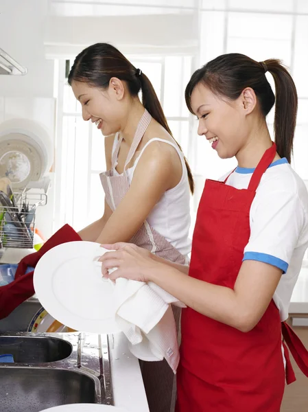 Frauen waschen Teller nach dem Essen — Stockfoto