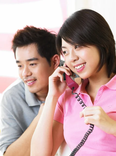 Junger Mann hört seiner Frau beim Telefonieren zu — Stockfoto