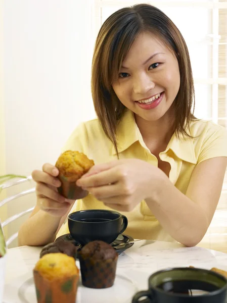 Ung kvinna smaka muffin — Stockfoto