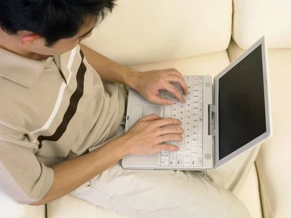 Ung man ger trodde att något medan du arbetar på sin laptop. — Stockfoto