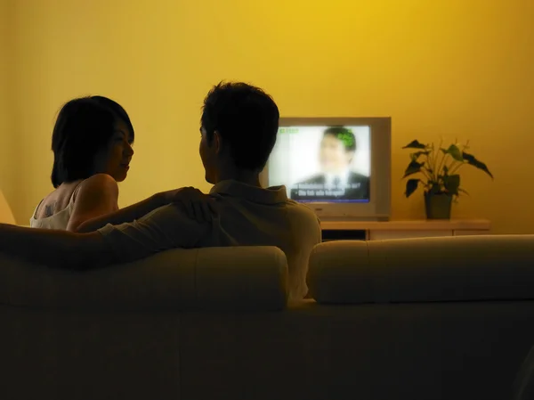 Ungt par framför TV i vardagsrummet — Stockfoto