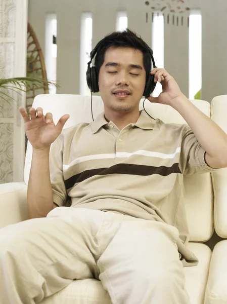 Jonge man uit zich in de muziek die hij luistert — Stockfoto